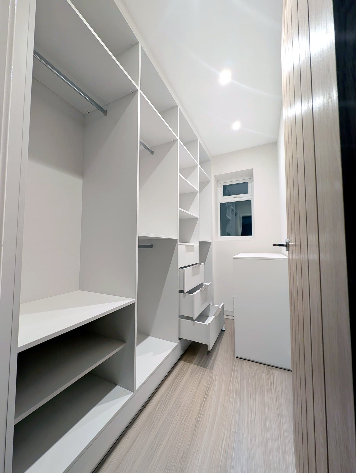 White walk-in dressing room with open shelving and hanging rails